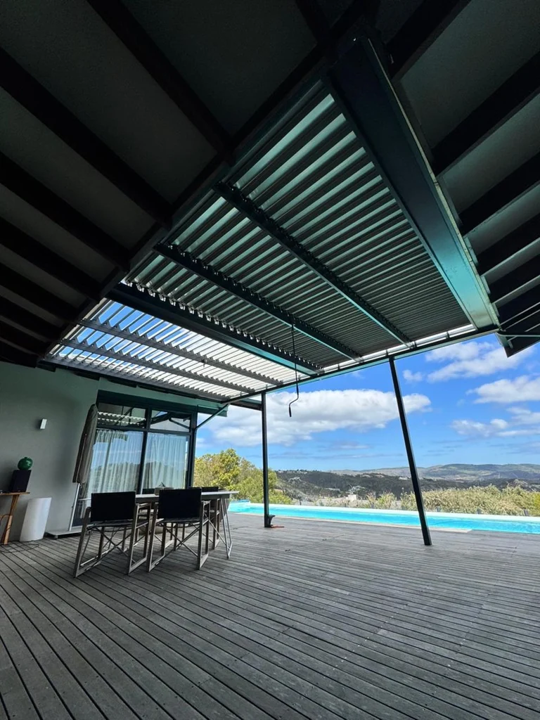 A black louvre awning by Custom Blinds Shutters & Awnings extending a deck towards a pool, Simola Golf Estate, Knysna, Garden Route, South Africa