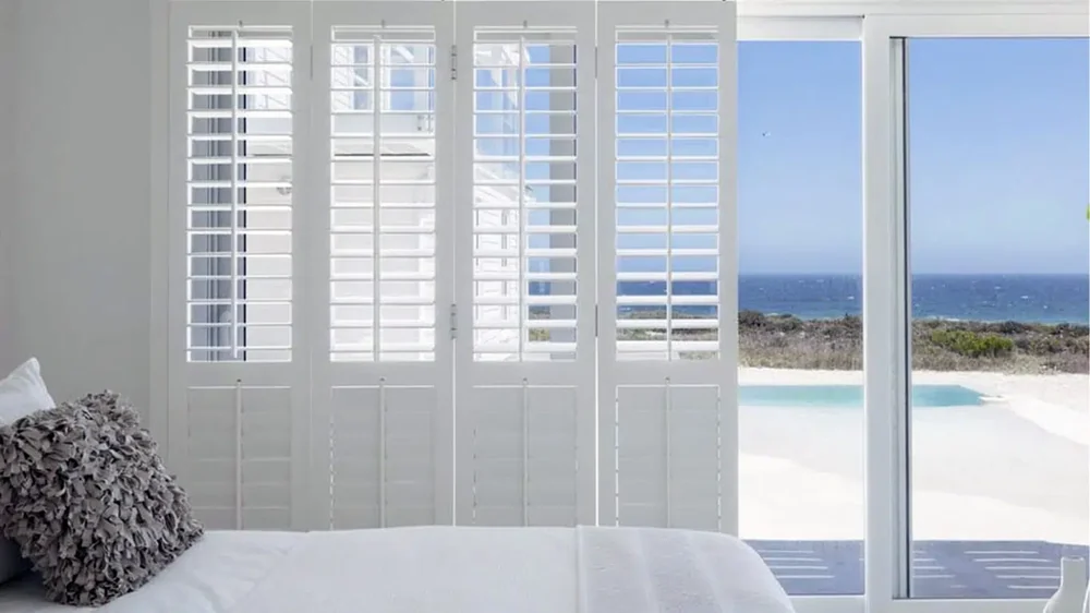 White PVC indoor shutters fitted to a window reveal by Custom Blinds Shutters & Awnings