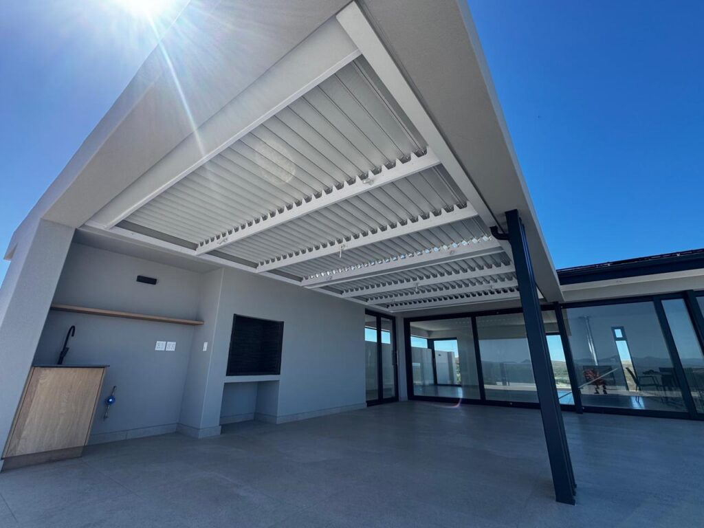 Outdoor patio with louvre pergola, built-in braai and mountain views. Custom Blinds installation