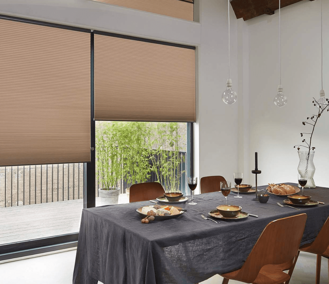 Light-filtering honeycomb blinds in a dining room with soft natural light, Custom Blinds Shutters & Awnings
