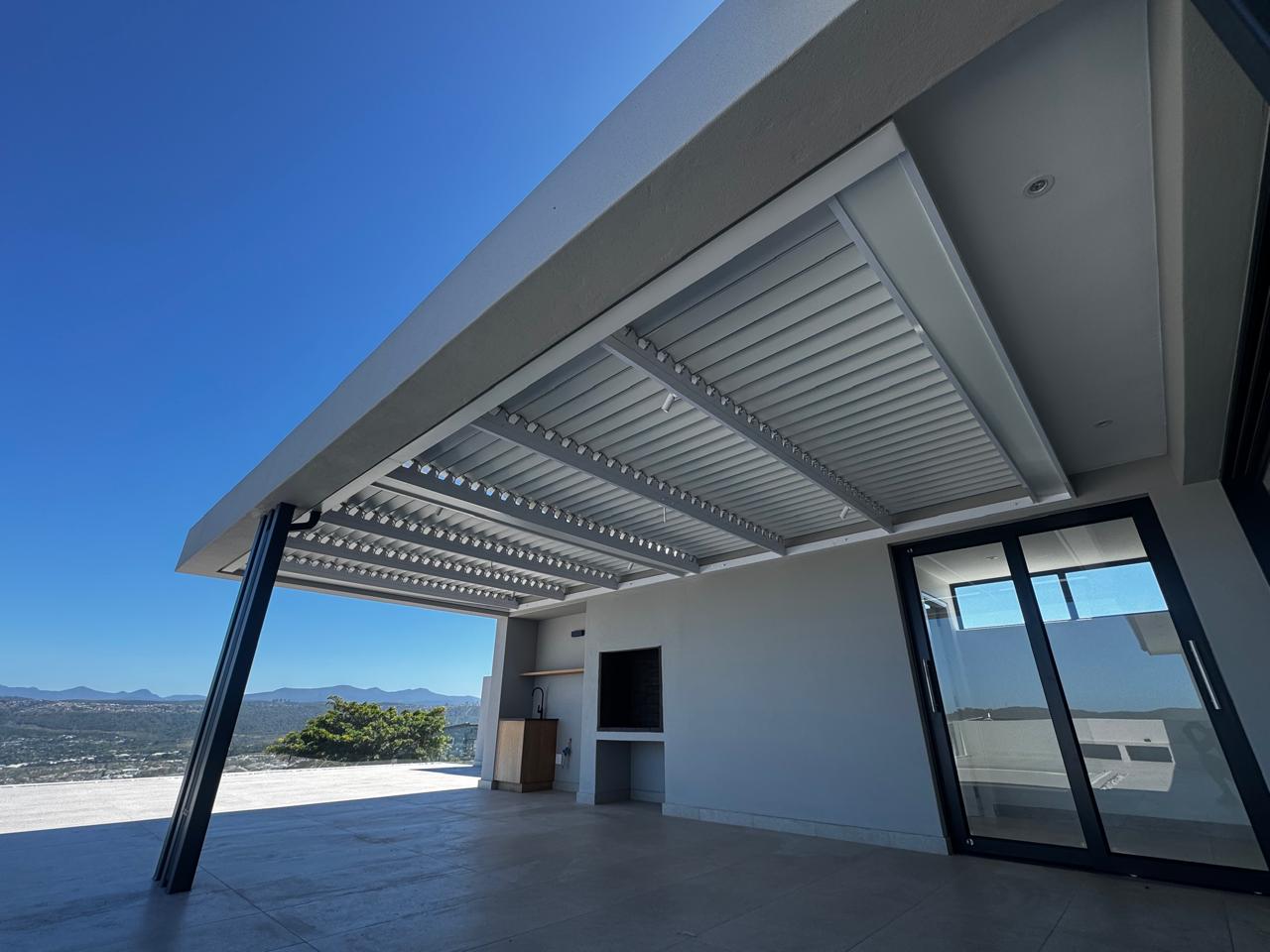 Louvred awning over patio at Fernwood Estate Knysna with mountain views, installed by Custom Blinds