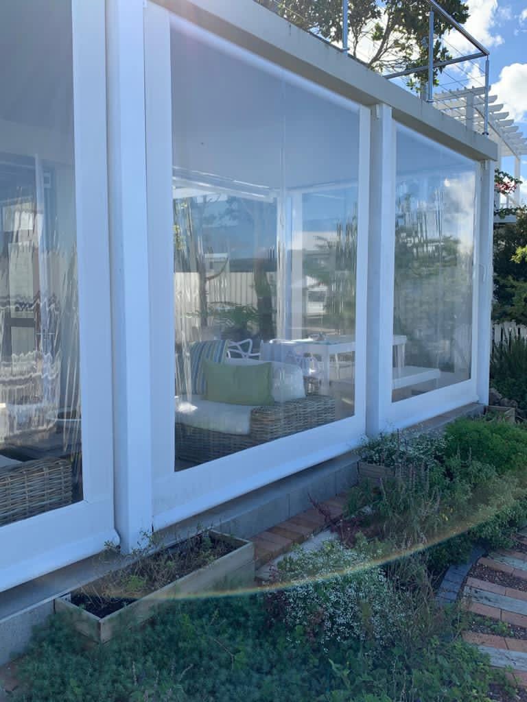 Clear PVC outdoor blinds with maximised view panels and white borders on a South African patio by Custom Blinds
