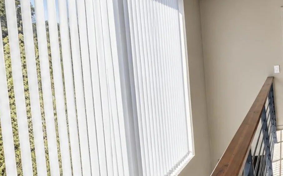 White vertical blinds filtering sun over a staircase at Simola Estate, Knysna, by Custom Blinds Shutters & Awnings