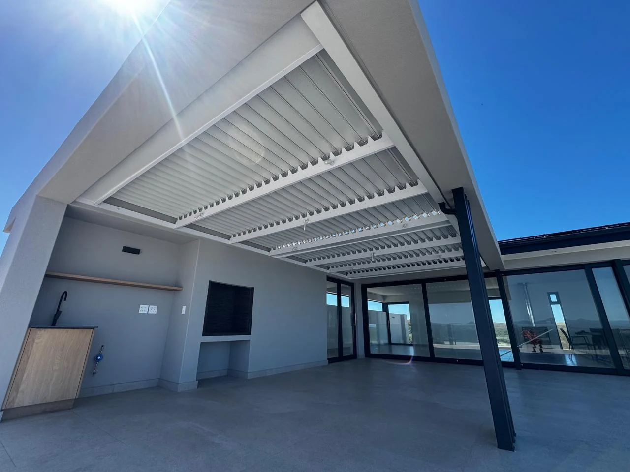 White louvred roof awning expertly installed, modern outdoor entertainment patio by Custom Blinds Shutters & Awnings, Fernwood Estate, Knysna, Garden Route, South Africa