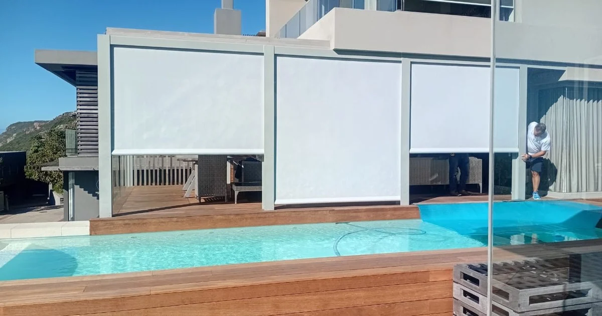 White screen outdoor blinds lowered beside a poolside deck, Custom Blinds Shutters & Awnings