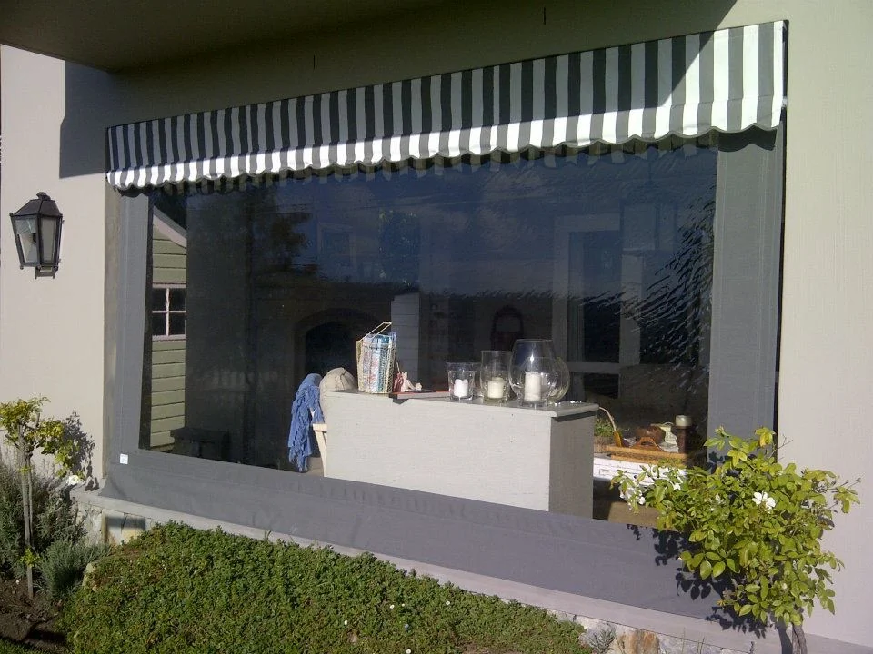 A green and white striped canopy awning over a wide serving window with a dark outdoor blind lowered beneath it, by Custom Blinds Shutters & Awnings, Garden Route, South Africa