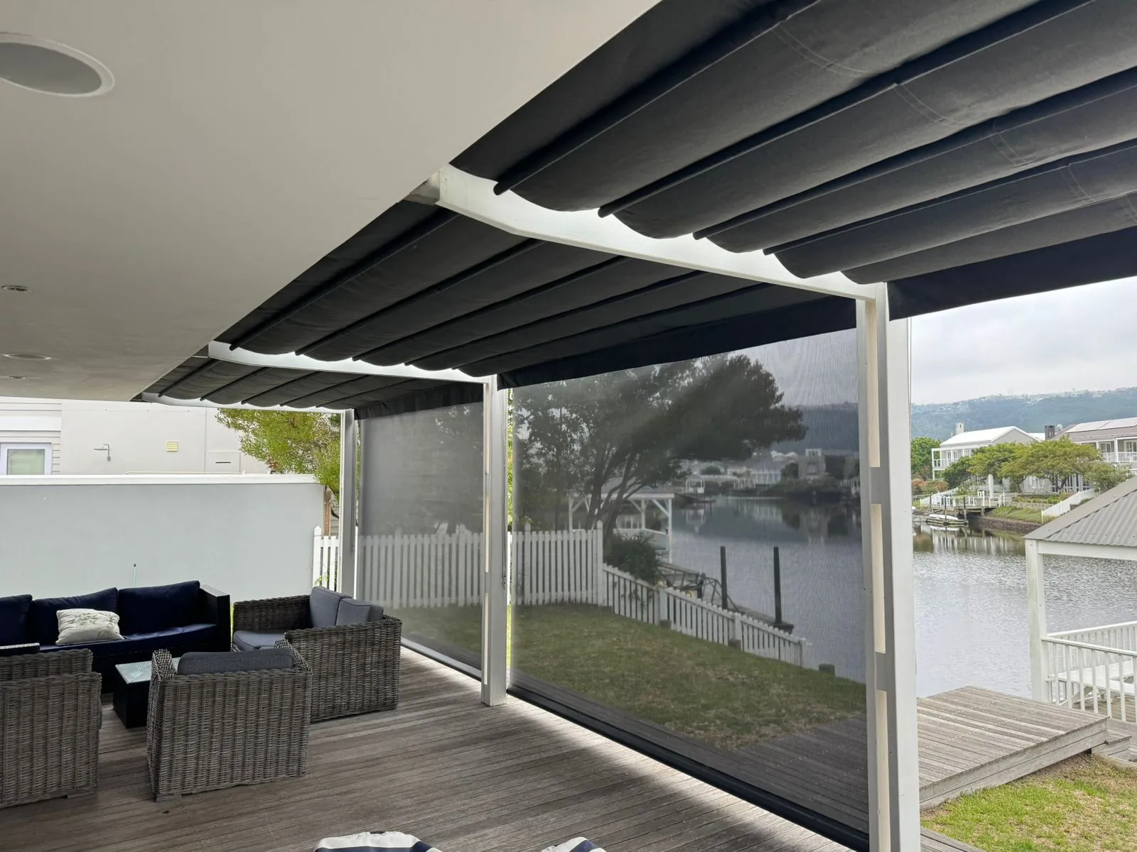 Retractable awning and Sheerweave screen blinds on a waterfront deck, Thesen Island, Knysna, by Custom Blinds Shutters & Awnings