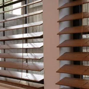 Custom Blinds Shutters & Awnings South Africa Wooden Venetian blinds on two open windows let soft sunlight in, offering privacy and a peaceful view over your home garden. Garden Route & Online