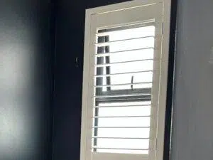 Custom Blinds South Africa White shutters on a dark wall let in just enough sun, brightening the room whilst keeping it cool and private. George Garden Route & Online