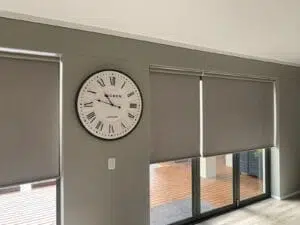 Custom Blinds Shutters & Awnings South Africa blockout roller blinds on home windows offer privacy and light, with doors leading out to a sunny terrace—perfect for relaxed living. Garden Route & Online