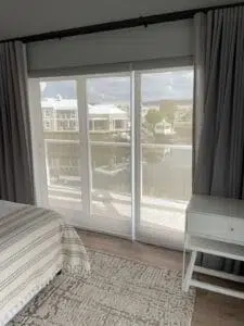 Custom Blinds Shutters & Awnings South Africa Sheer roller blinds on glass doors let in soft Thesen Island daylight, brightening the bedroom and keeping canal views clear and private. Garden Route & Online