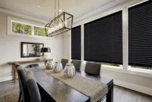 Custom Blinds Shutters & Awnings South Africa A sleek dining room with dark blockout roller blinds offers style and privacy, perfect for sharing meals in your sunny South African home. Plettenberg Bay Garden Route & Online