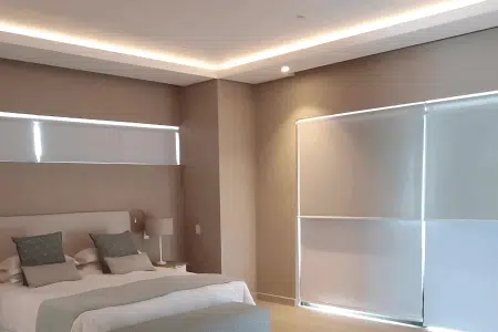 Duo roller blinds in bedroom with large windows letting in light while giving privacy by Custom Blinds South Africa