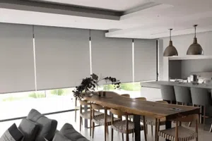Custom Blinds South Africa Bright kitchen and dining space with wooden table, grey bar stools, and roller blinds that let in light while ensuring your privacy. Plettenberg Bay Garden Route & Online