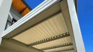 Custom Blinds South Africa Modern home exterior with white louvre roof awnings lets you control sunlight, keeping your Simola patio cool beneath clear blue skies. Simola Golf estate living Knysna Garden Route & Online