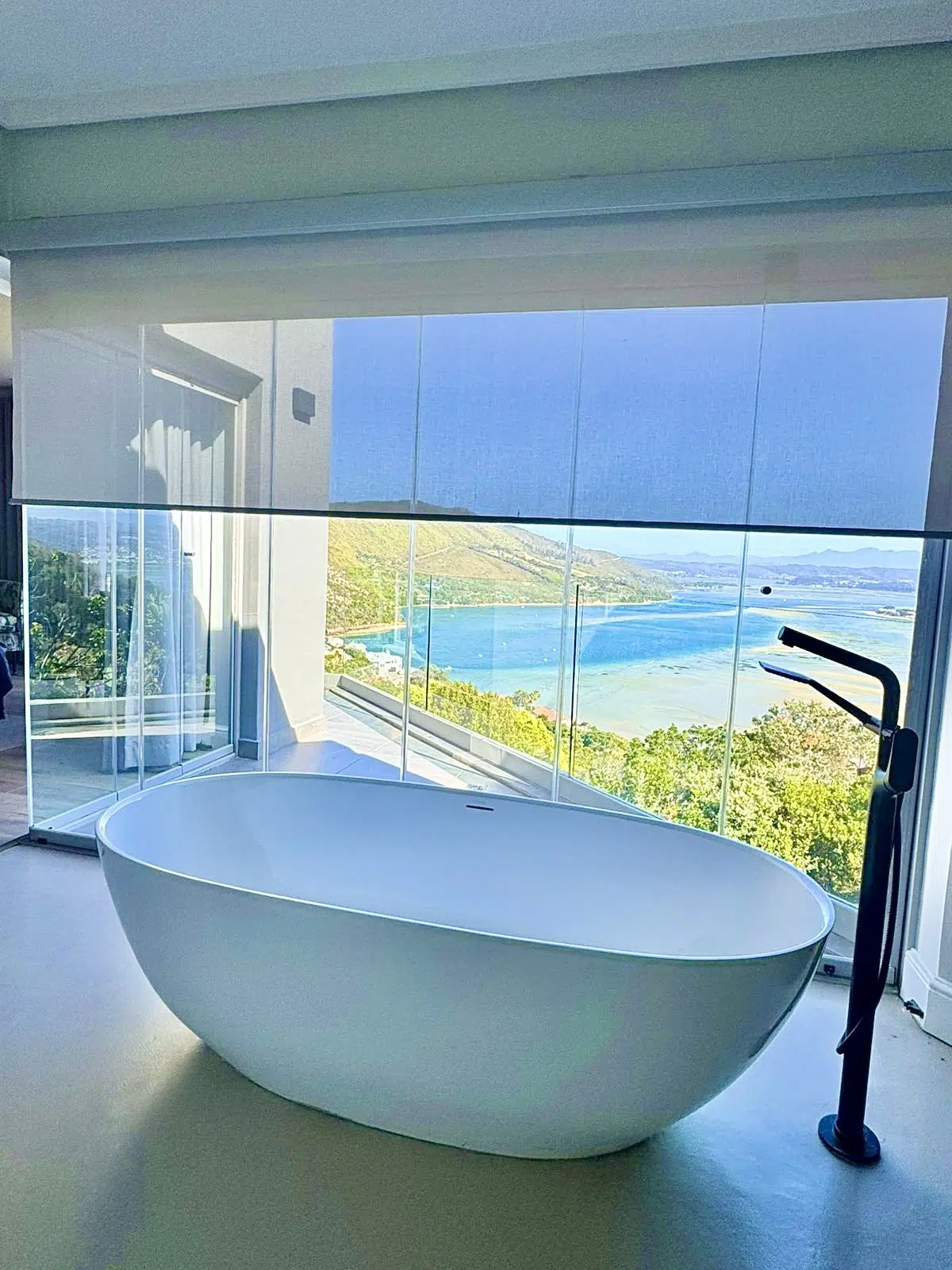 Sheer roller blinds in a Knysna Heads home with sea view from the bath