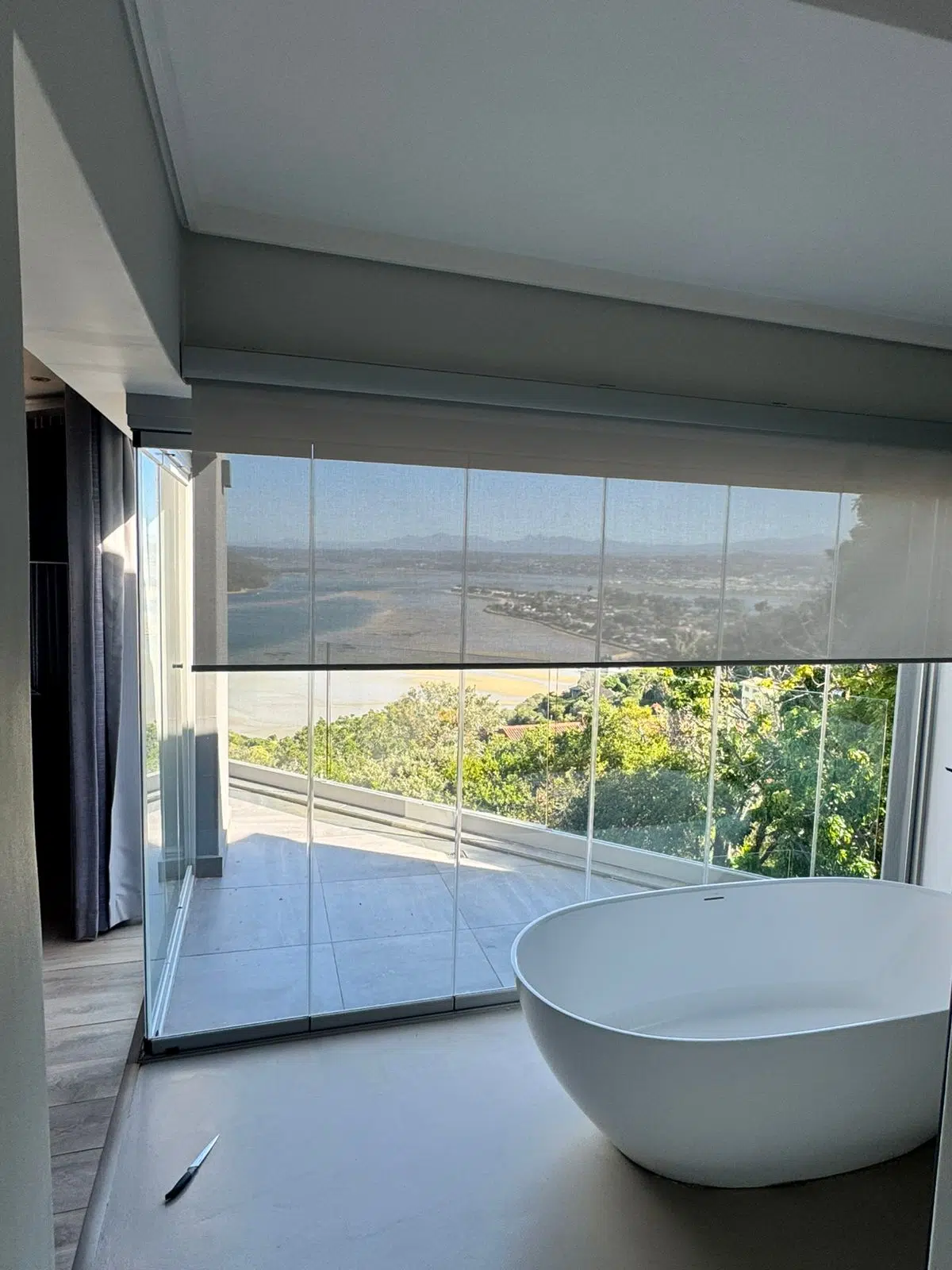 Roller blinds filtering morning light in a modern Knysna bathroom