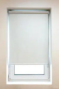 Custom Blinds Shutters & Awnings South Africa A white roller blind covers most of a window in a bright room, letting light in below for privacy and a fresh, airy home feel. Garden Route & Online