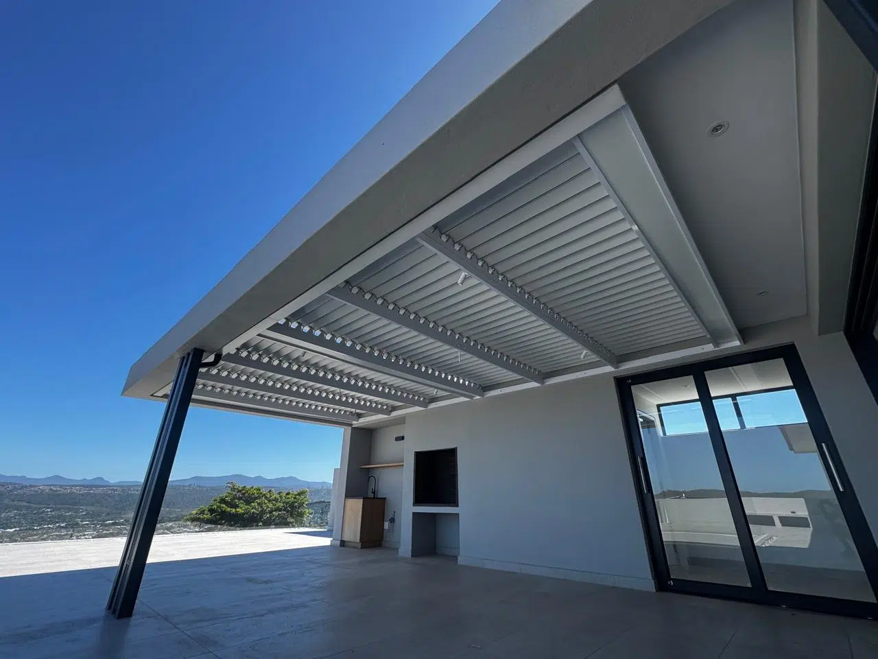 Retractable patio shade awning extending over an outdoor entertainment area