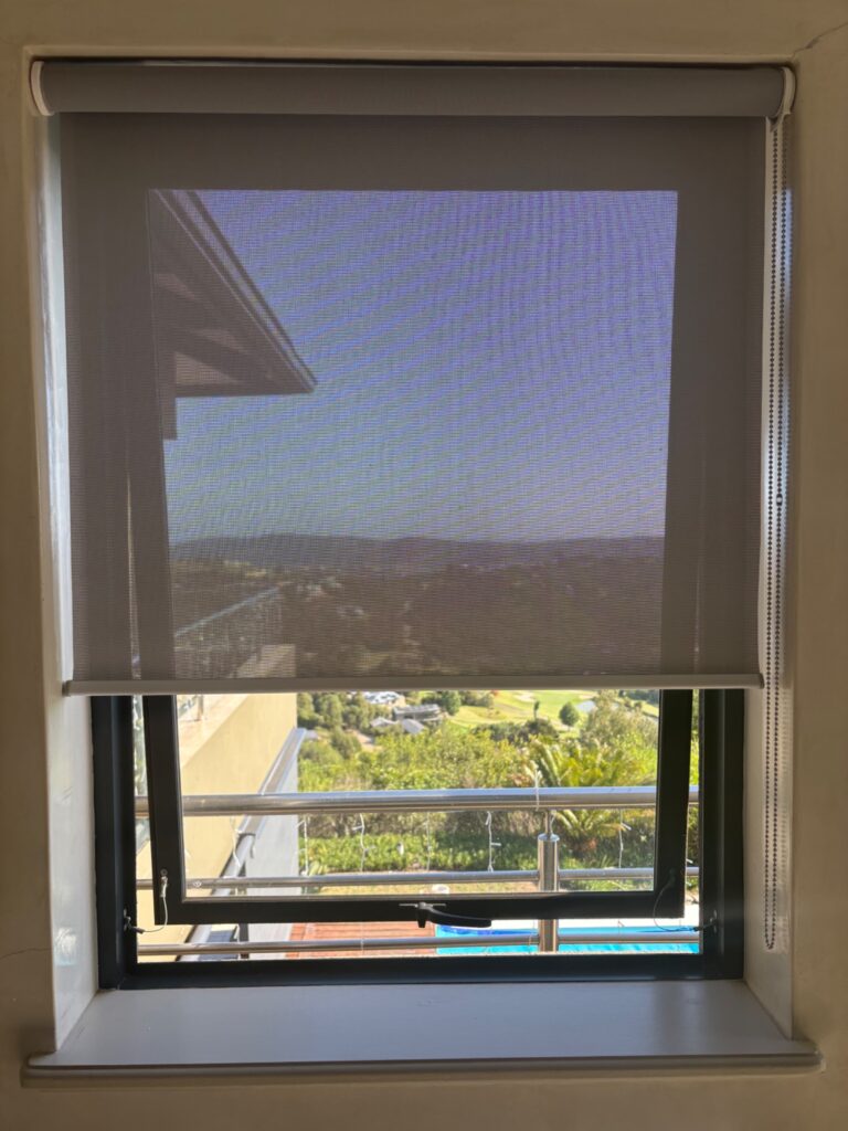 No-drill sheerweave roller blind fitted on aluminium window at Simola Estate Knysna. Tension-mount system by Custom Blinds South Africa