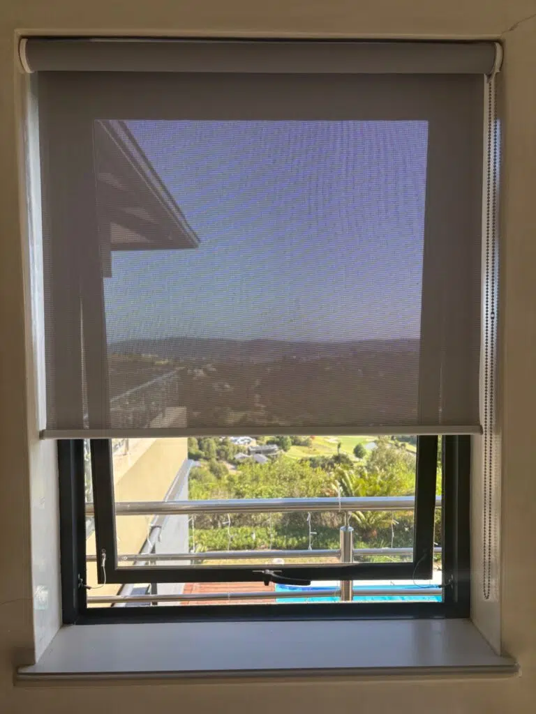 No-drill sheerweave roller blind fitted on aluminium window at Simola Estate Knysna. Tension-mount system by Custom Blinds South Africa