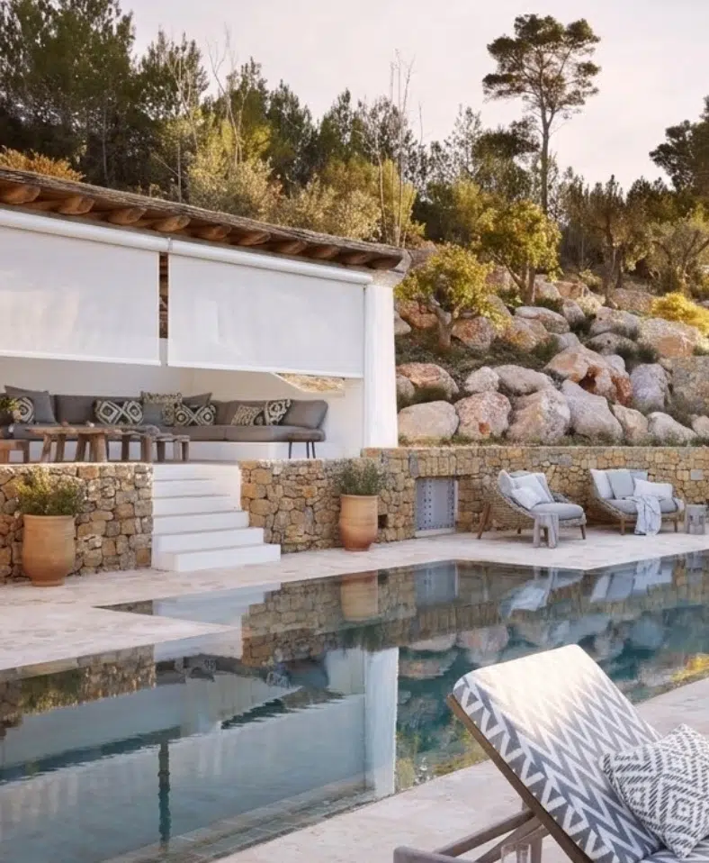 White outdoor roller blinds on a poolside pavilion