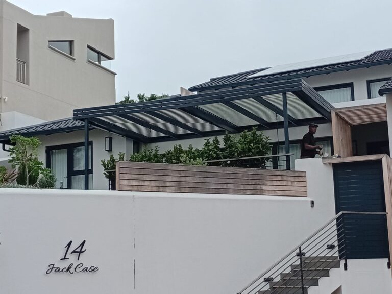Aluminium louvred awning exterior view over patio at Beachy Head, Plettenberg Bay, installed by Custom Blinds