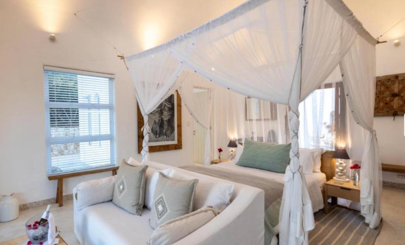 Aluminium venetian blinds in a luxury resort suite with four-poster bed, Mozambique