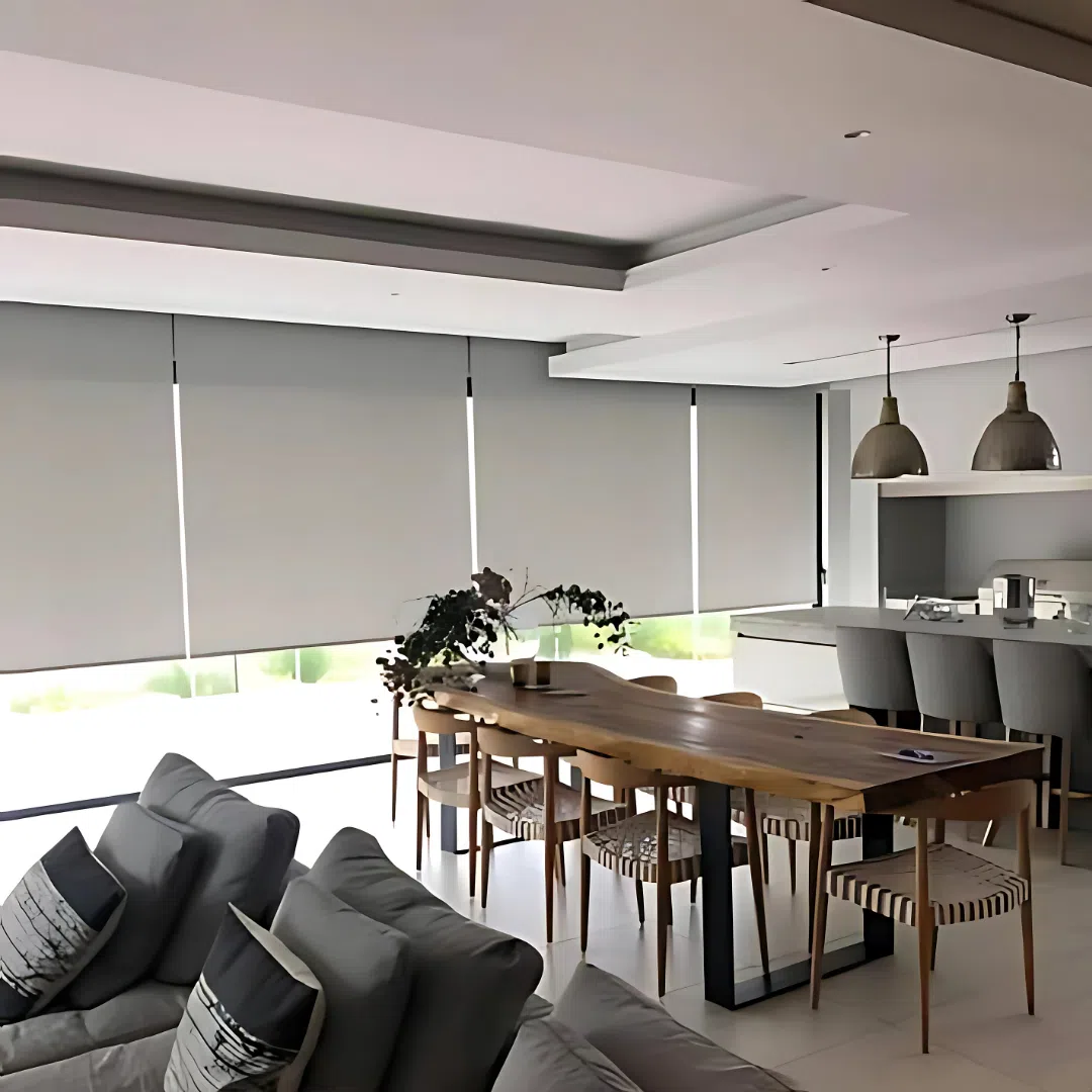 Roller blinds in an open plan dining room with live-edge table and garden views