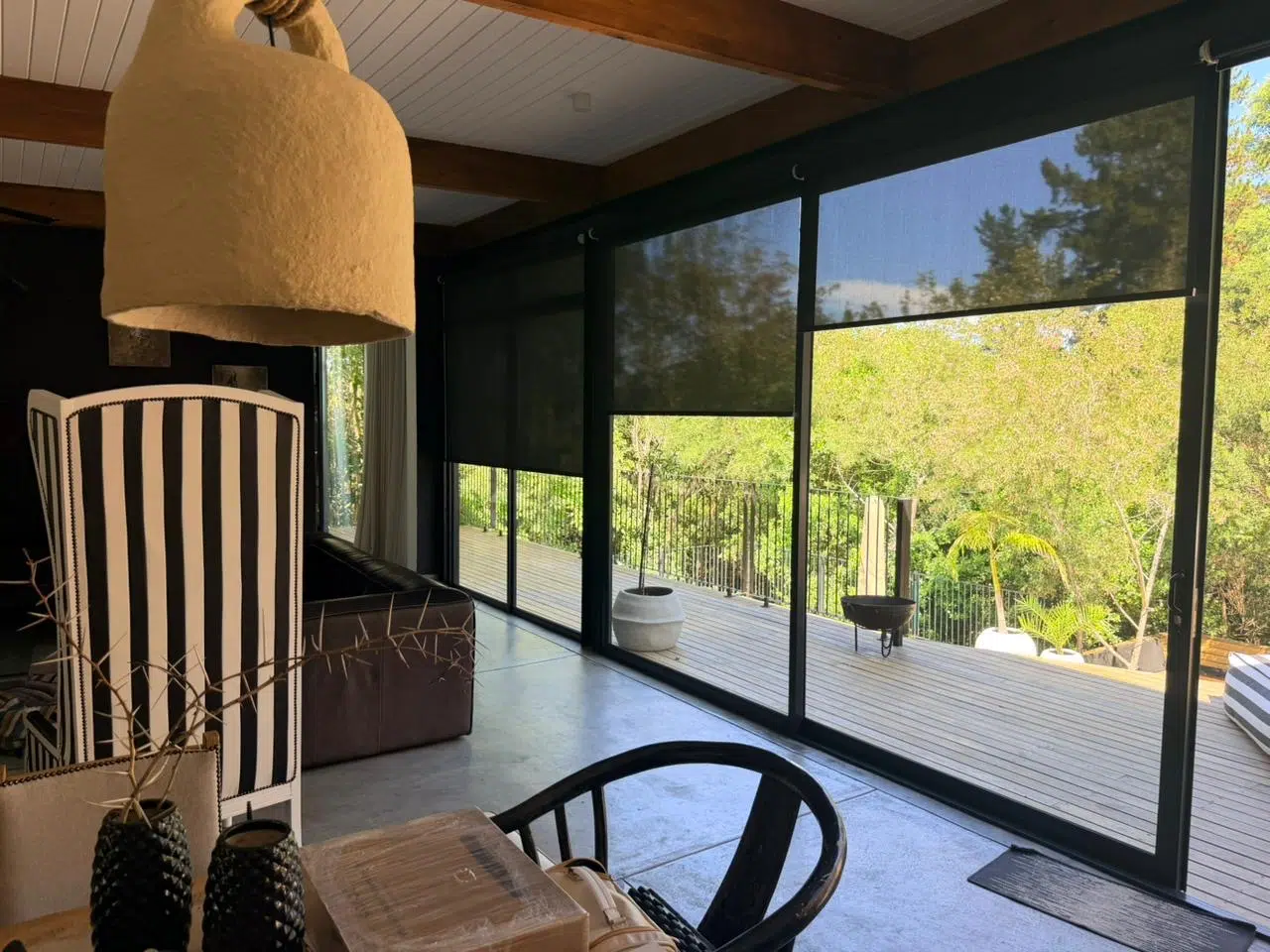 Toned sheer roller blinds on a Garden Route deck — full-width outdoor blind installation with view-through fabric, Custom Blinds Knysna