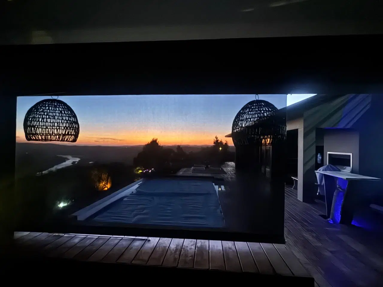 Sunworker outdoor screen blind installed on a pool deck at Simola Estate Knysna by Custom Blinds South Africa — view over the Knysna River and Outeniqua Mountains at sunset