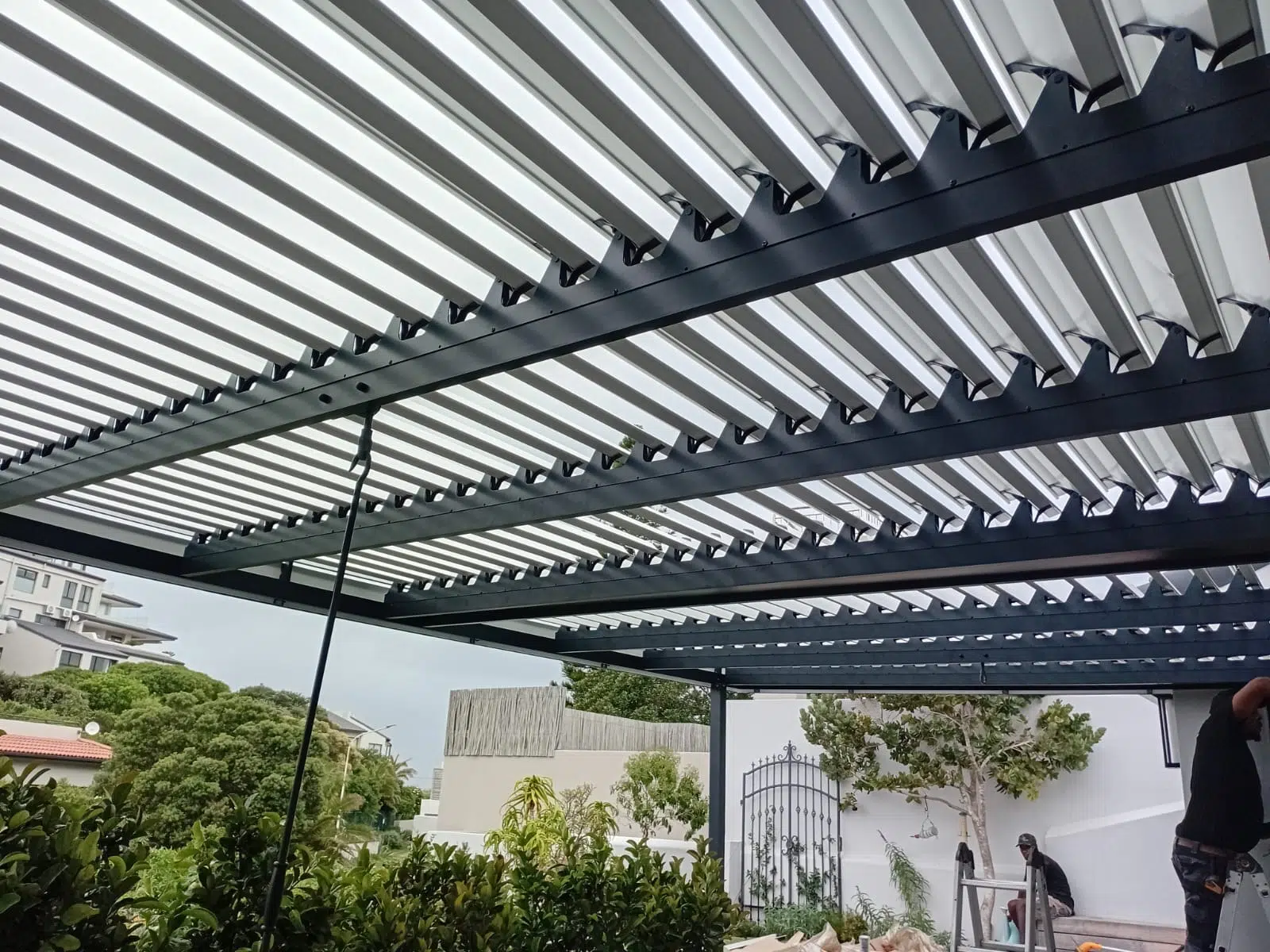 Adjustable louvre awning installation over a patio in Buffalo Bay, Garden Route. Custom Blinds Shutters and Awnings.