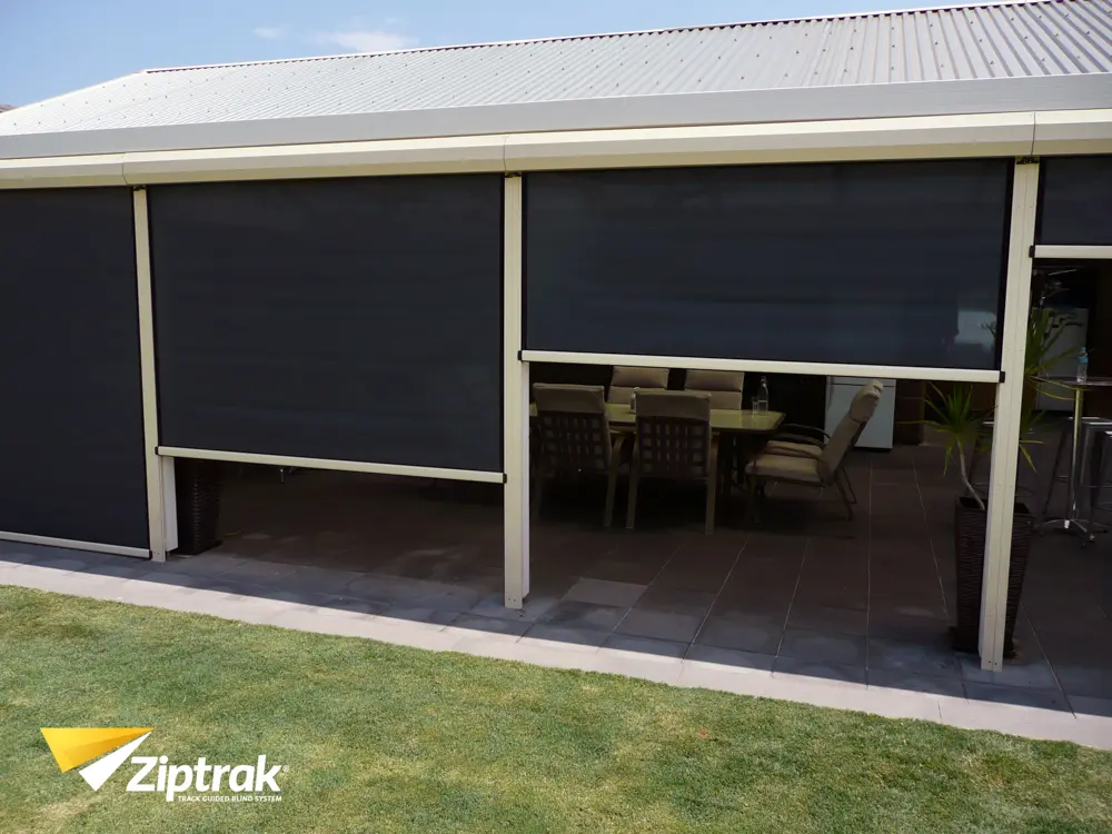 Ziptrak outdoor blinds in charcoal sunscreen mesh on a residential rear patio, multiple bays operated independently, supplied by Custom Blinds authorised Ziptrak retailer Garden Route