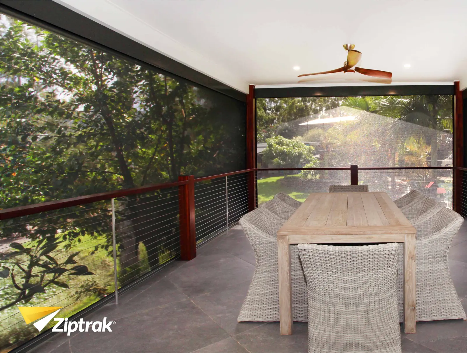 Ziptrak outdoor blinds on a covered verandah with dining table, multiple bays in charcoal sunscreen mesh, supplied by Custom Blinds authorised Ziptrak retailer Garden Route