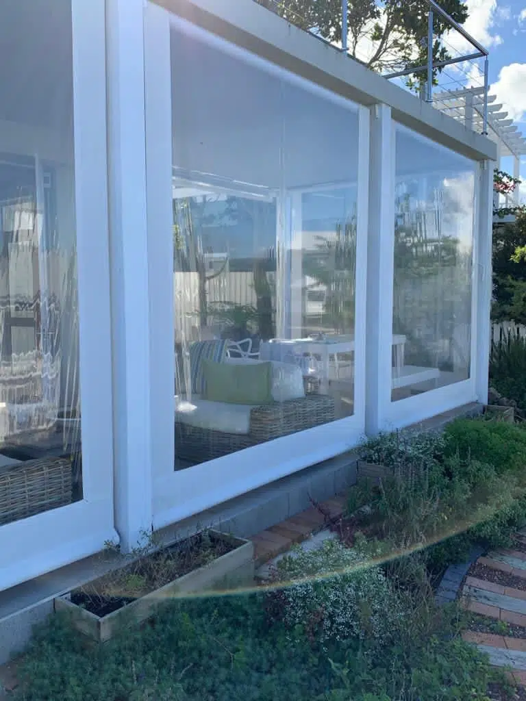 Clear PVC outdoor blinds with maximised view panels and white borders on a South African patio by Custom Blinds