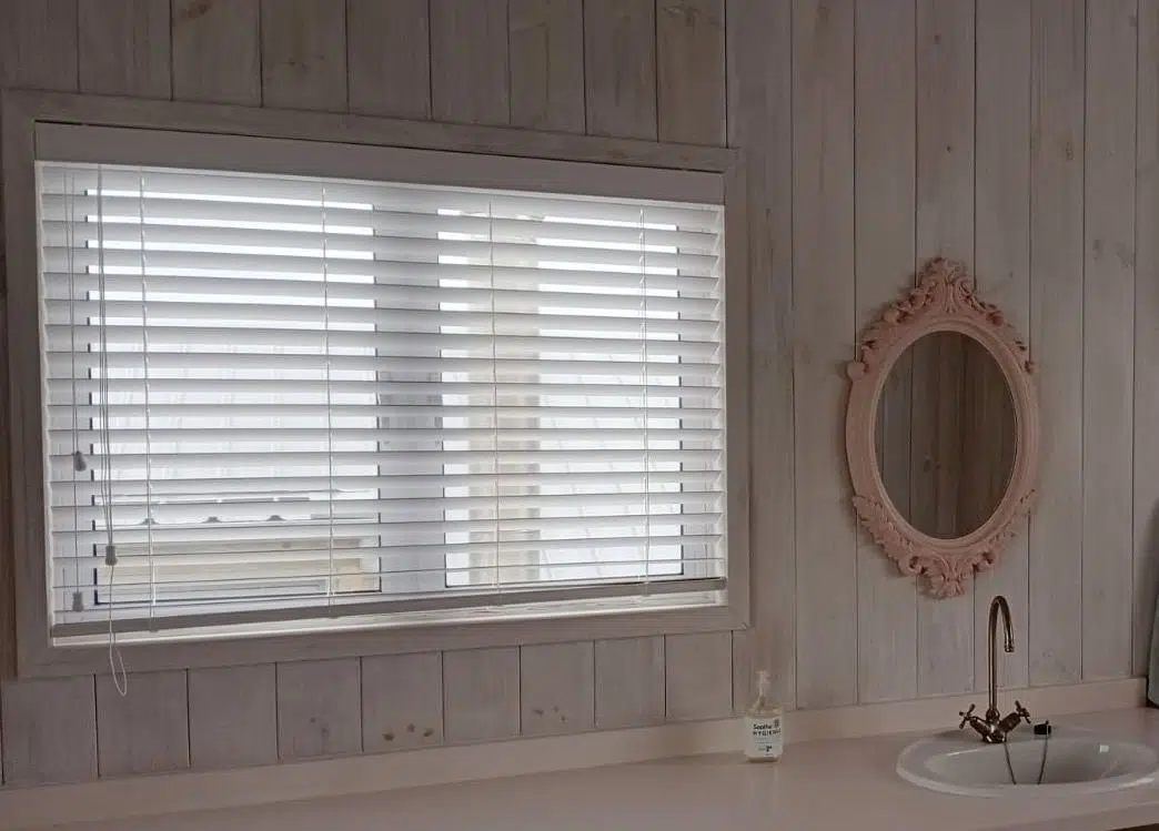 White Plaswood faux-wood Venetian blind fitted in a coastal bathroom in Buffalo Bay, Garden Route. Custom Blinds Shutters and Awnings.