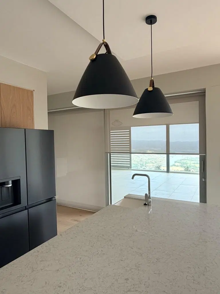 Roller blind on a kitchen sliding door with a Knysna lagoon view, Garden Route, fitted by Custom Blinds Shutters and Awnings