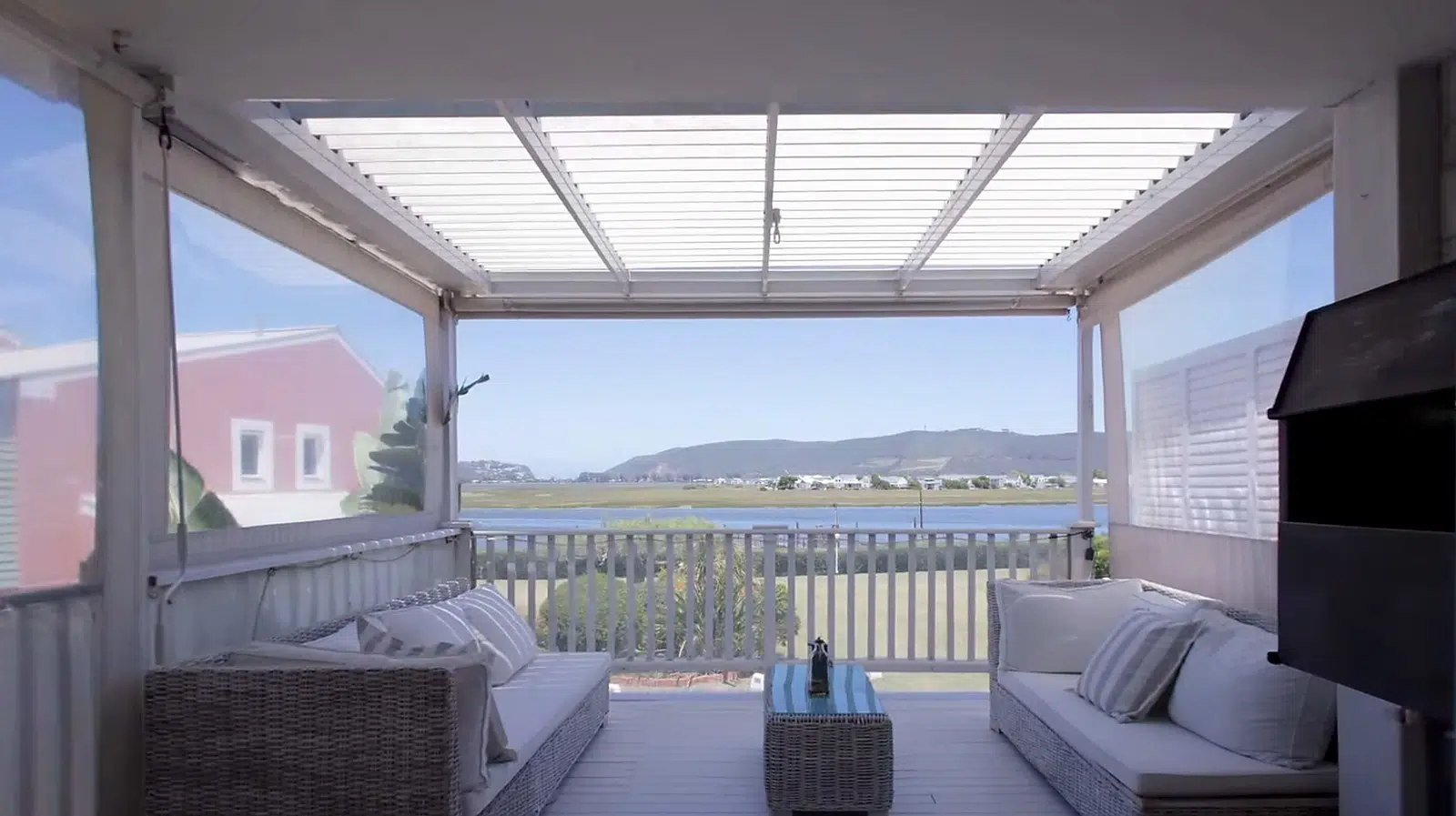 Louvred awning with Ziptrak outdoor blinds installed by Custom Blinds in the Garden Route.