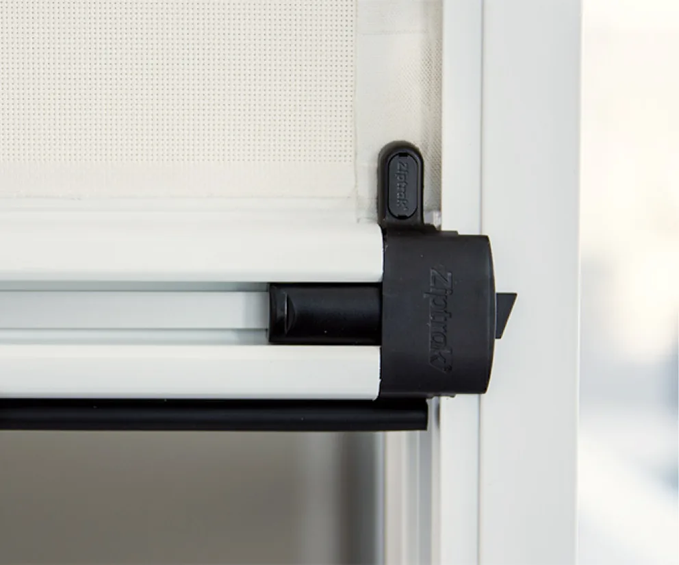 Close-up of a Ziptrak® outdoor blind bottom rail with its black locking handle in the side track, from Custom Blinds Shutters & Awnings, authorised Ziptrak® agent, Garden Route, South Africa. Image credit Ziptrak®